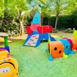 Jardin avec bateau pirate, chenille colorée et petit train sur revêtement souple